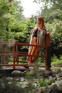 Happy ginger hair woman in well-groomed park or garden. freedom and healthy way of life. female in