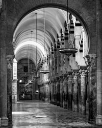 Empty narrow corridor along pillars