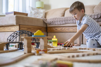 Boy playing with toy blocks at home