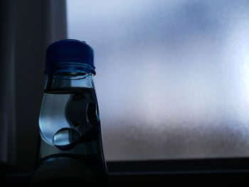 Close-up of glass bottle on table at home