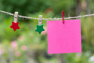 Close-up of adhesive note hanging on clothesline