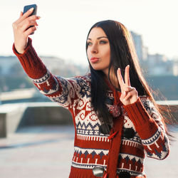 Young woman photographing with mobile phone