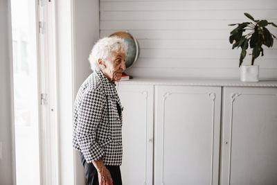 Side view of man standing at home