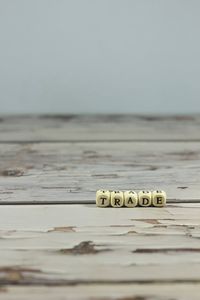 Close-up of text on table at beach against sky