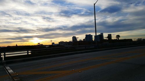 View of road against cloudy sky at sunset