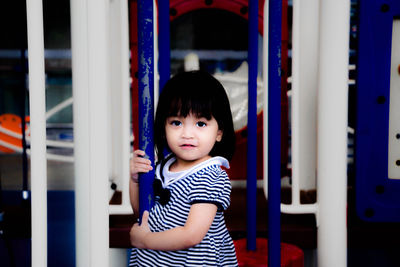 Portrait of girl standing by outdoor play equipment