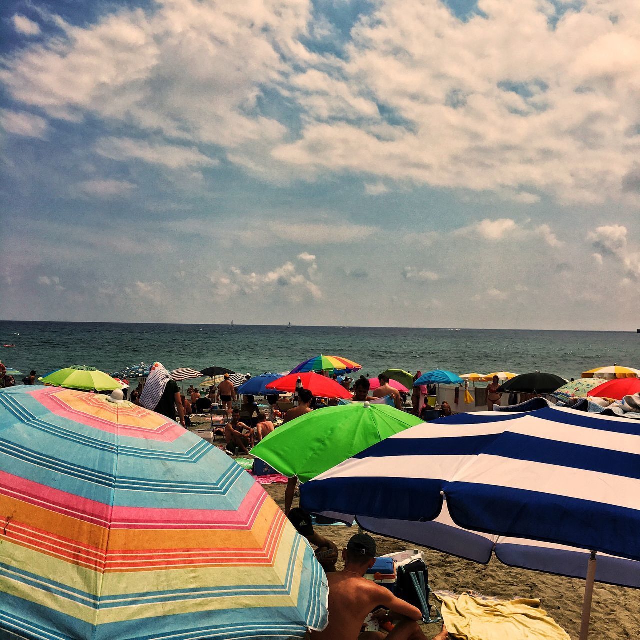 PEOPLE AT BEACH AGAINST SKY