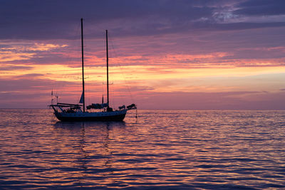 Boat sailing in sea at sunset