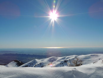 Scenic view of snowcapped mountains against clear blue sky