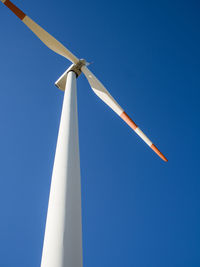 Low angle view of windmill against clear blue sky