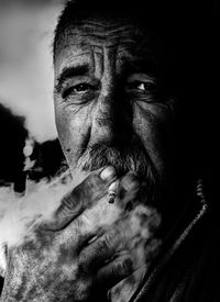 Close-up portrait of man smoking cigarette