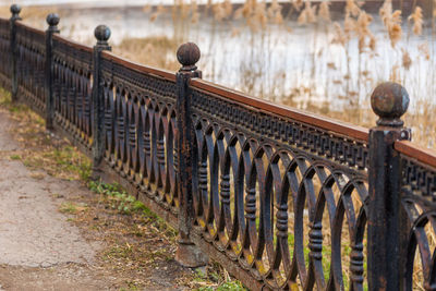 Row of rusted metal fence by street