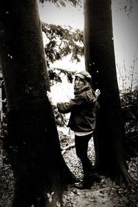 Full length of boy standing on tree trunk
