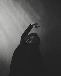 Portrait of woman standing against wall