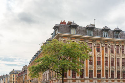 Low angle view of building and trees against sky