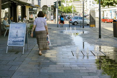 Rear view of man walking on street in city