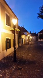 Illuminated street lights in front of buildings