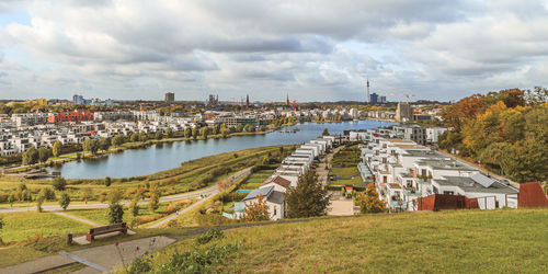Scenic view of river by buildings against sky