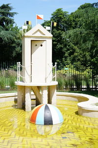 Gazebo by swimming pool in park against sky