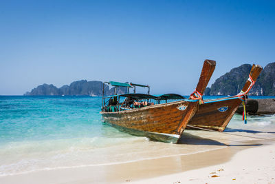 Fishing boat on beach against clear sky