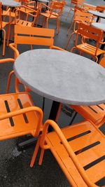 High angle view of empty chairs and tables at sidewalk cafe