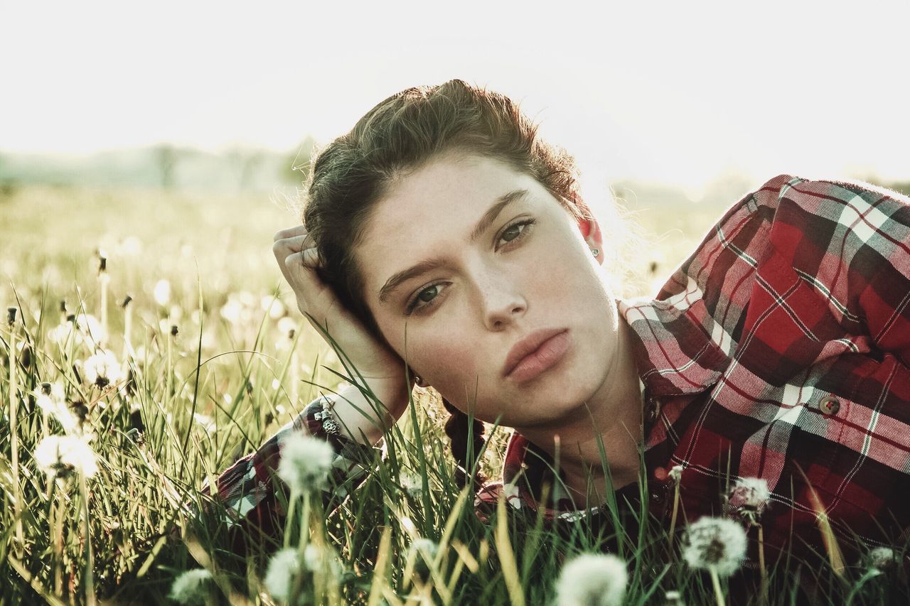 person, focus on foreground, field, lifestyles, leisure activity, flower, portrait, plant, looking at camera, young adult, close-up, growth, young women, front view, headshot, casual clothing, grass, nature