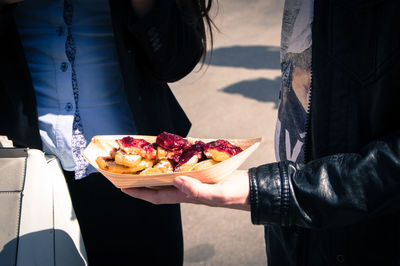 Midsection of man holding food while standing outdoors