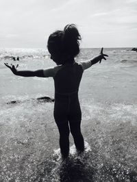 Full length of young woman standing at beach