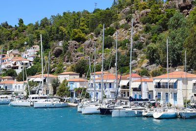 Sailboats moored in sea against sky