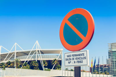 Low angle view of road sign against blue sky