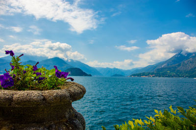 Scenic view of sea by mountains against sky