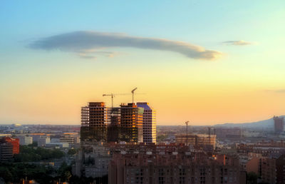 Modern buildings against sky during sunset