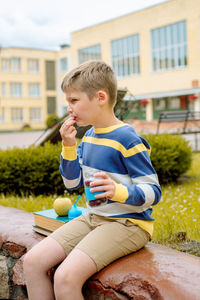 Boy eating food while sitting outdoors