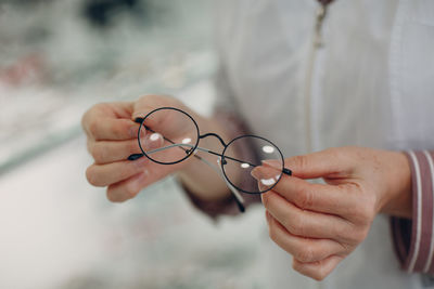 Close-up of woman hand holding eyeglasses