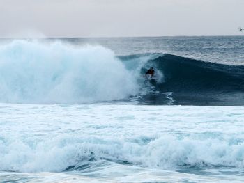 Man surfing in sea during sunset