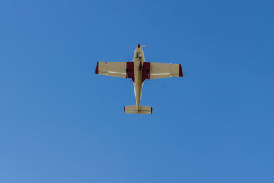 Directly below shot of airplane flying in clear blue sky