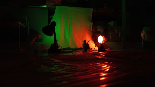 Low angle view of a dark studio room illuminated by red and green lights 