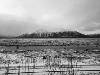 Scenic view of lake by mountains against sky