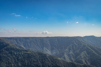 Misty mountain range covered with white mist and amazing blue sky