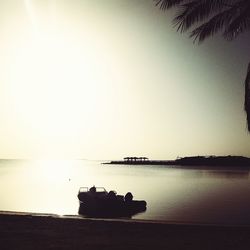 Silhouette boat in sea against clear sky