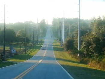 Empty road with trees in background