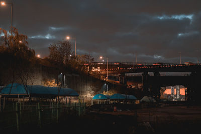 Illuminated bridge against sky at night