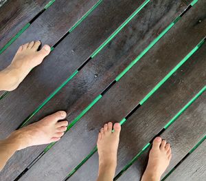 Low section of people on wooden floor