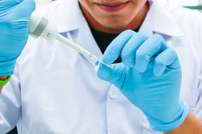 Close-up of surgeon hands wearing surgical gloves while holding medical equipment in hospital