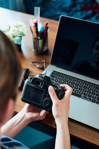 Female photographer working on photos on laptop and camera. woman editing retouching browsing photos