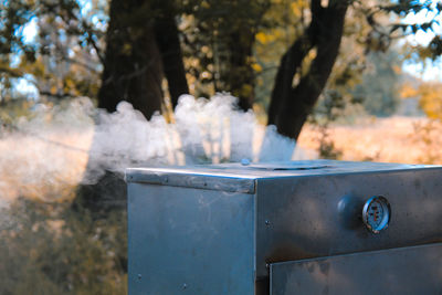 Close-up of garbage bin against trees