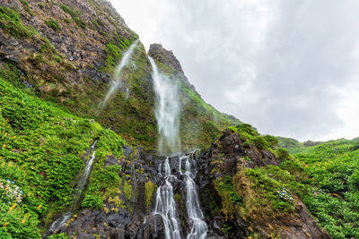 Scenic view of waterfall against sky