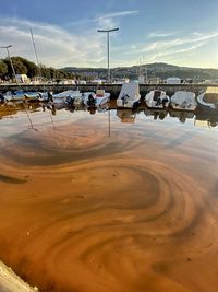 Sailboats moored at harbor against sky