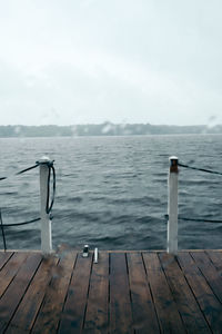 Close-up of pier over lake against sky