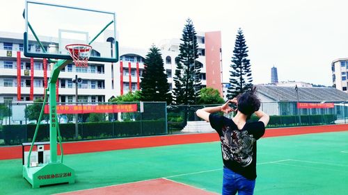 Rear view of man standing on basketball court